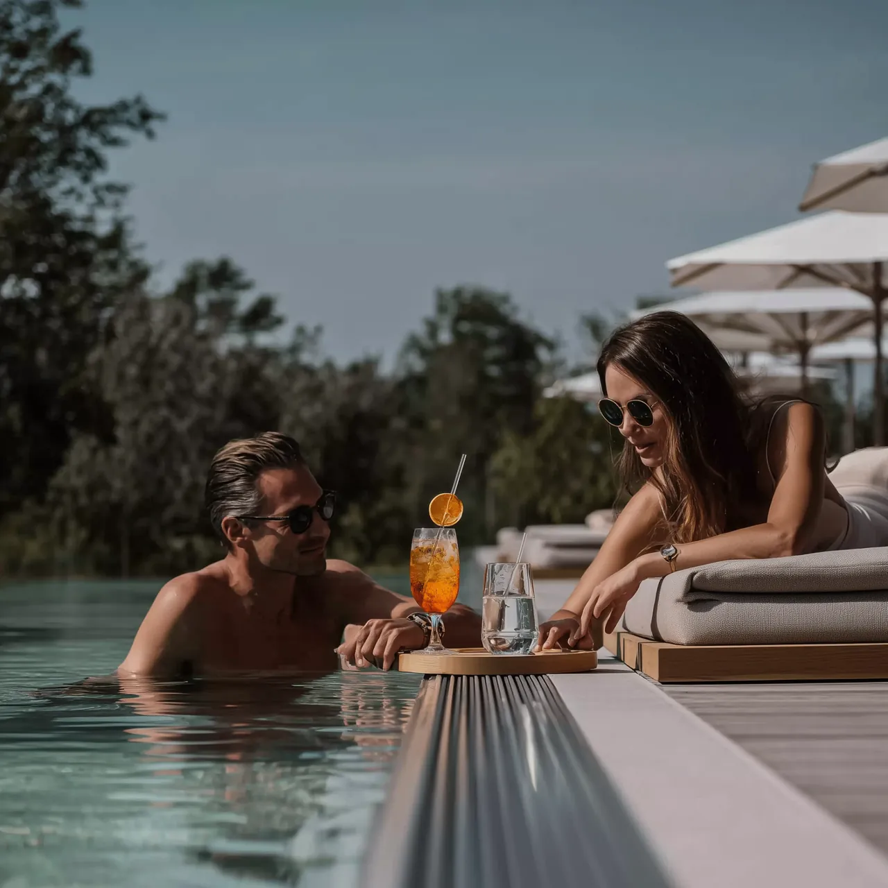 Klares Wasser am Beckenrand mit hellem Naturstein und sanften Schatten